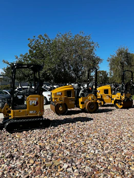 A row of various construction machines lined up, ready for sale.