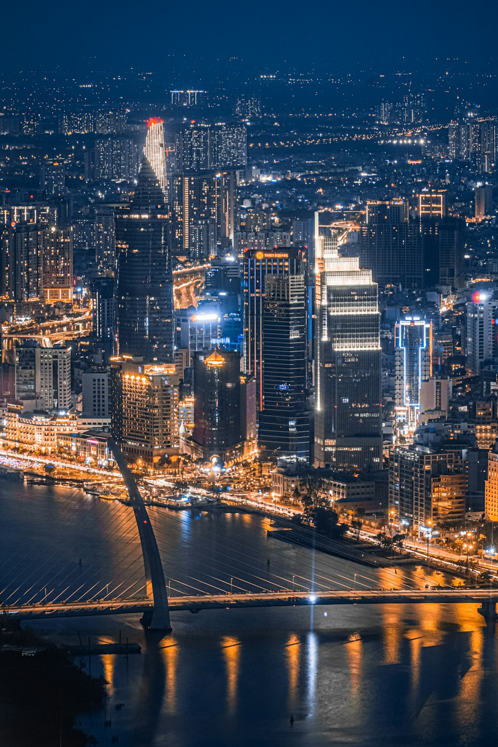 uma vista noturna de uma cidade com uma ponte em primeiro plano