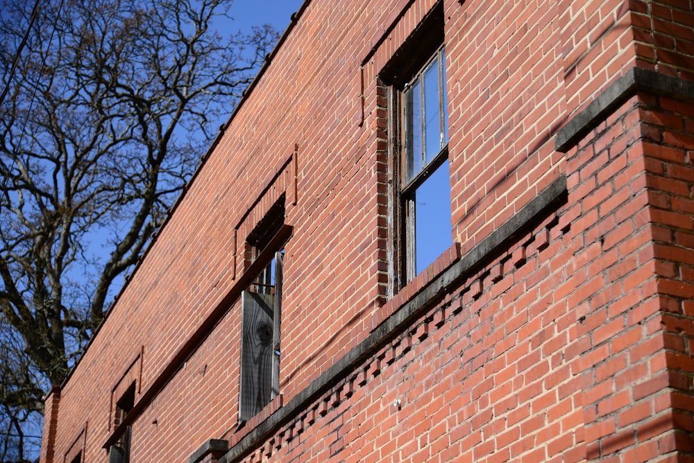 a red brick building with two windows and a clock