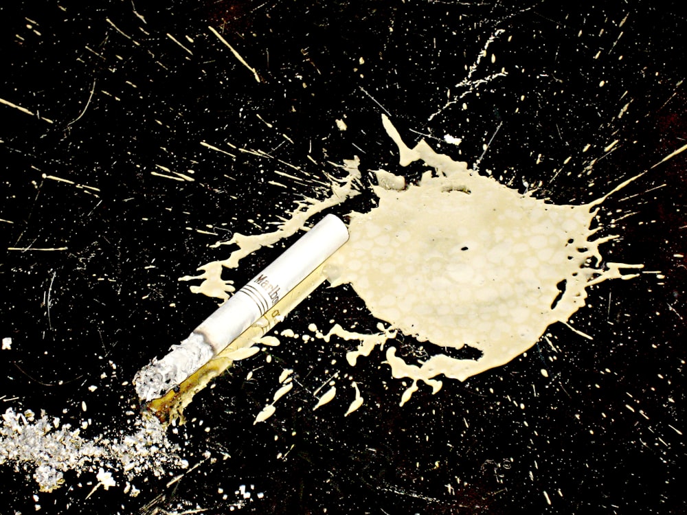 a cigarette with splashed wax on a dance floor