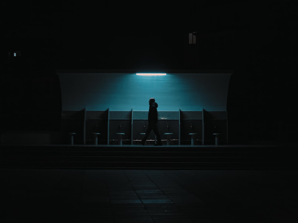 a person standing alone in a dark room