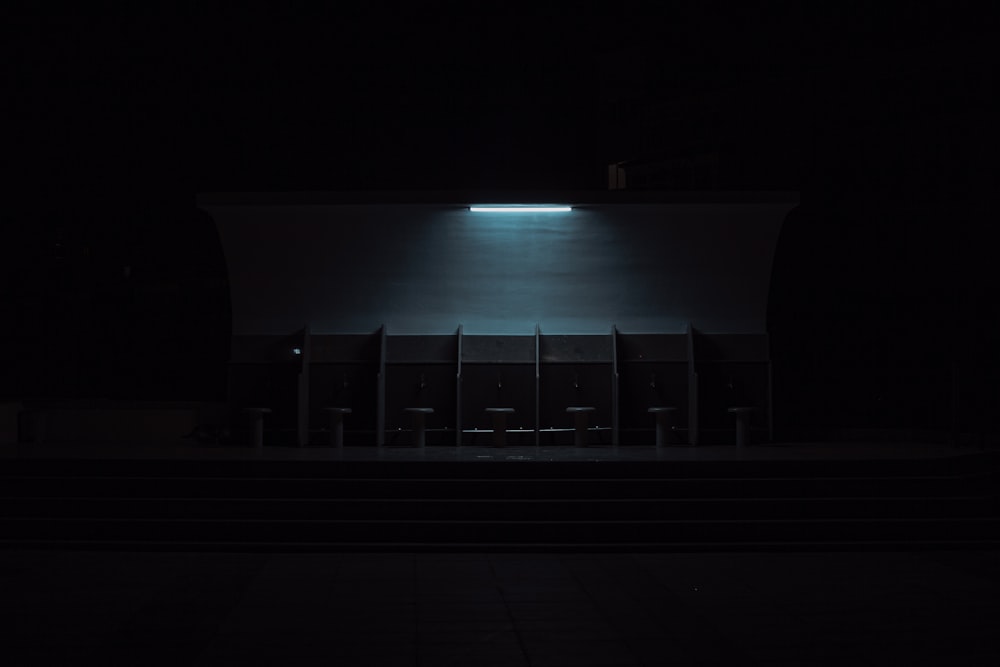 uma sala escura com uma fileira de cadeiras