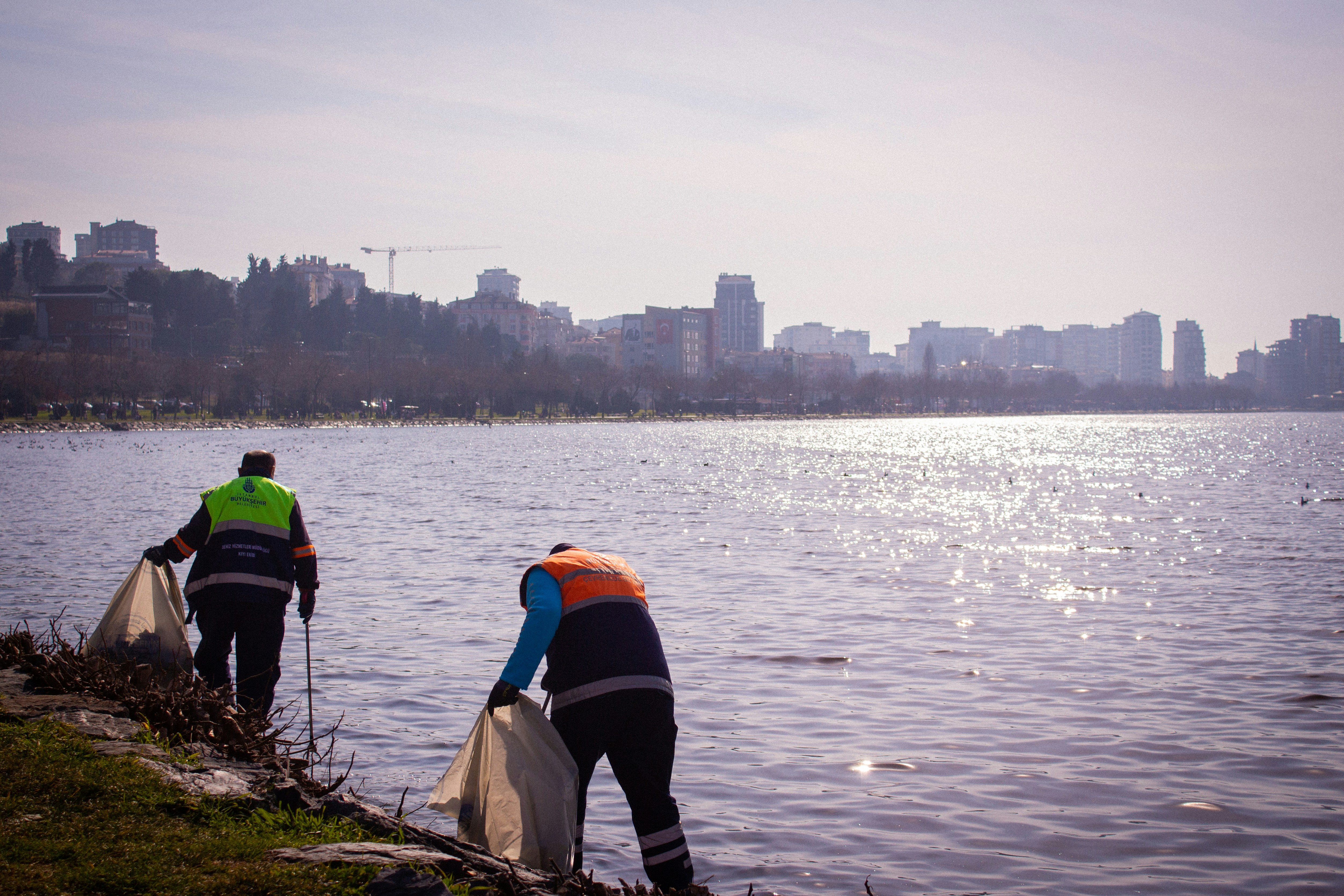 a couple of men standing next to a body of water