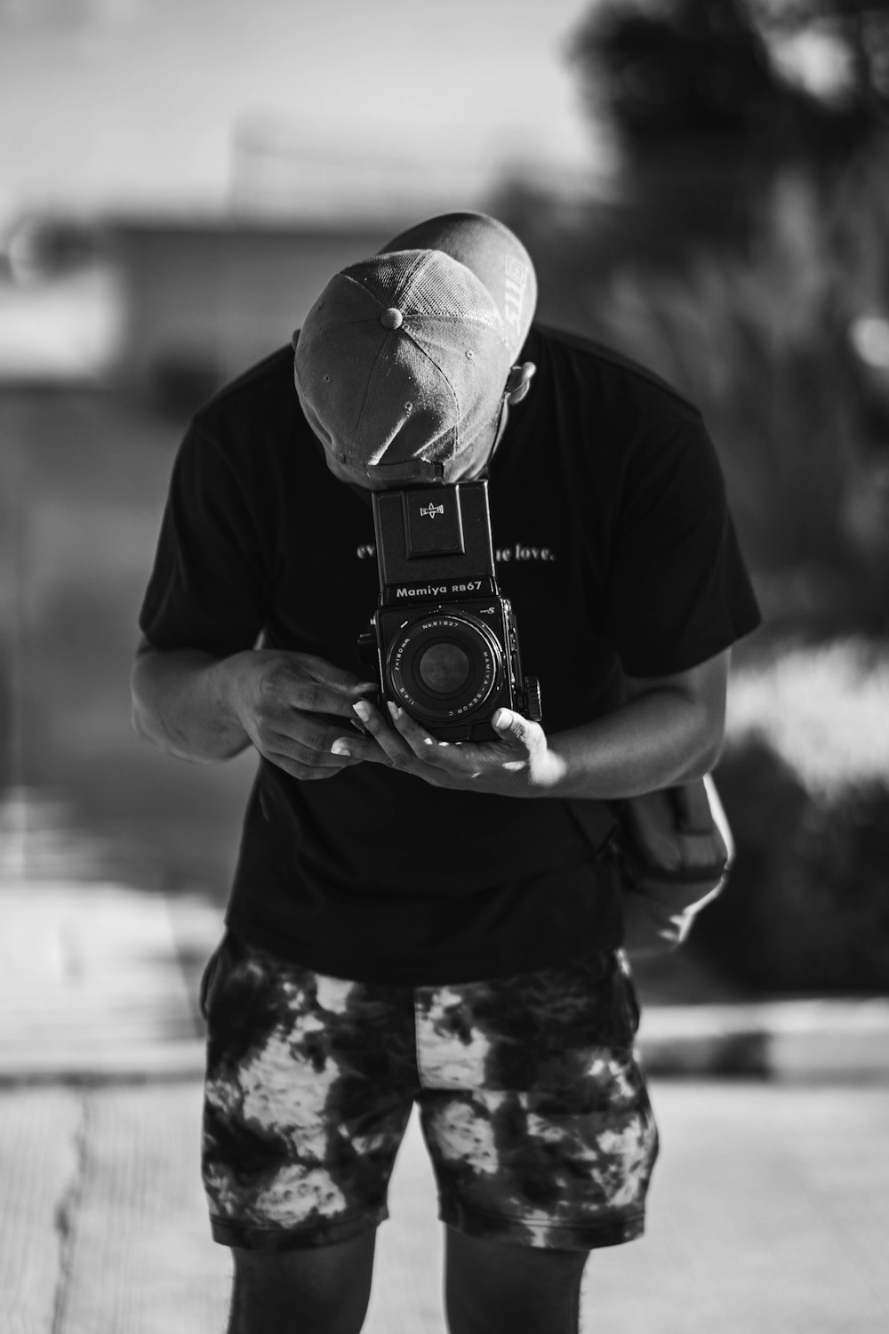 a man holding a camera while wearing a hat