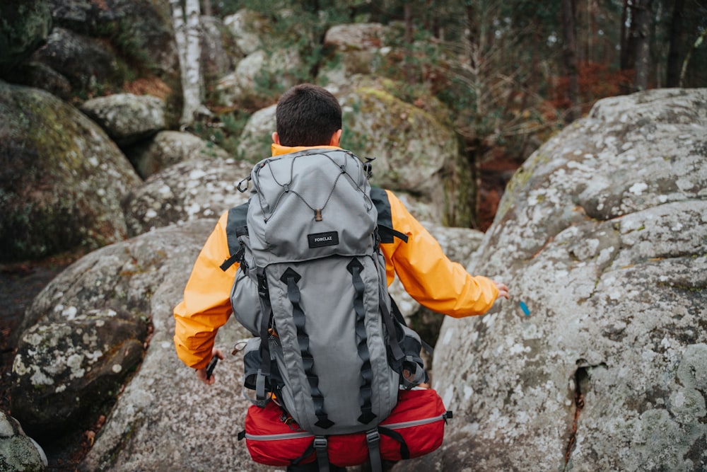 a man with a backpack walking on a rocky trail