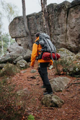 a man with a backpack walking up a trail