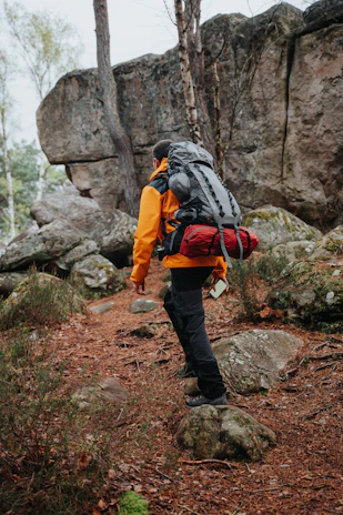 a man with a backpack walking up a trail