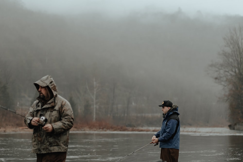 a man standing next to a man holding a fish