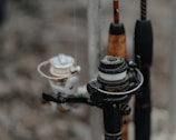 Several fishing reels are attached to rods, showing a variety of rods and reels close together. The focus is on the intricate details of the reels, which appear to be wet, suggesting they have been used recently or are in a humid environment.
