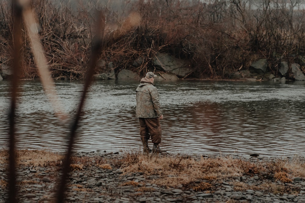 a man standing next to a body of water