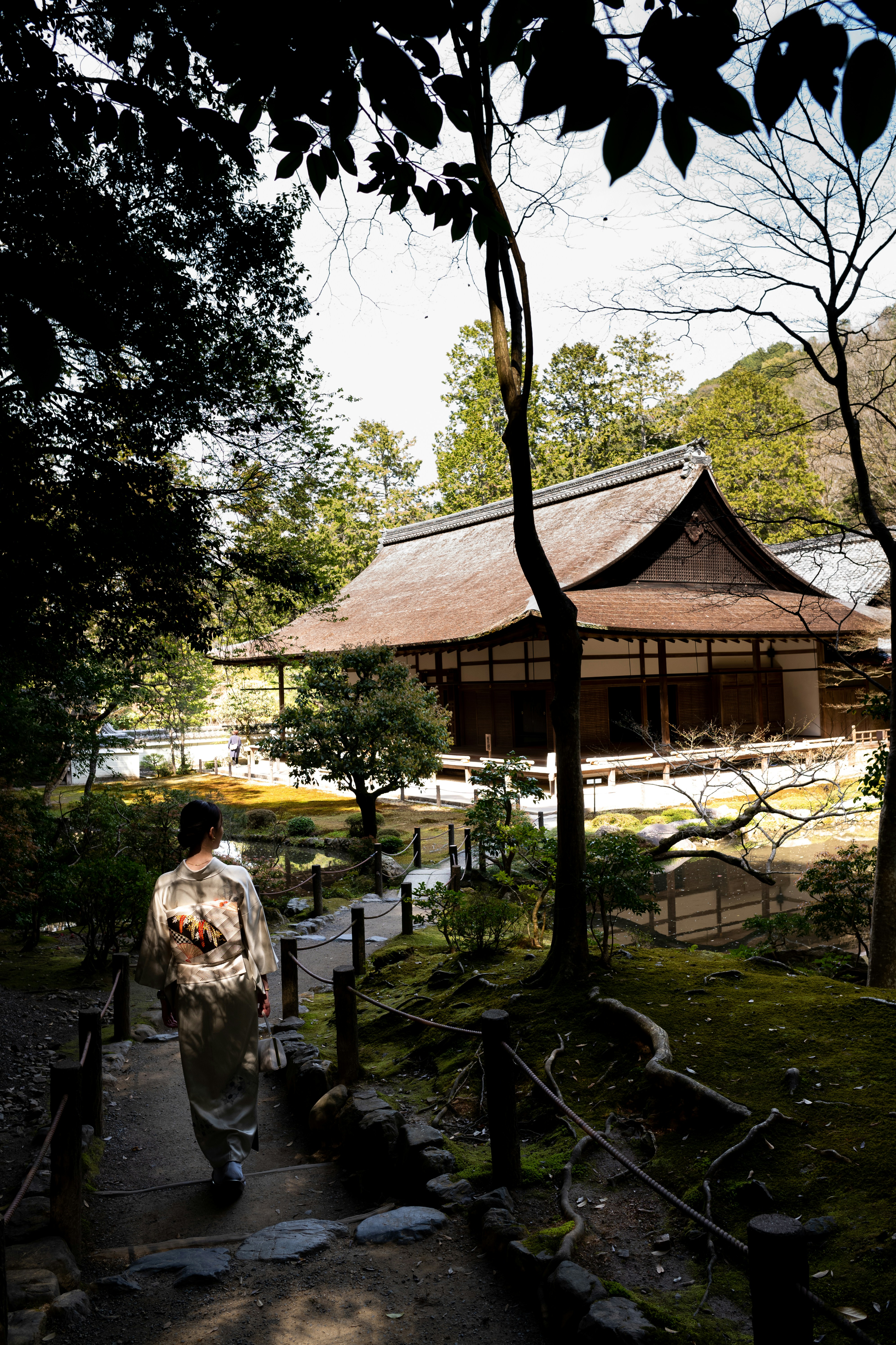 Eine Frau in einem Kimono geht einen Pfad entlang