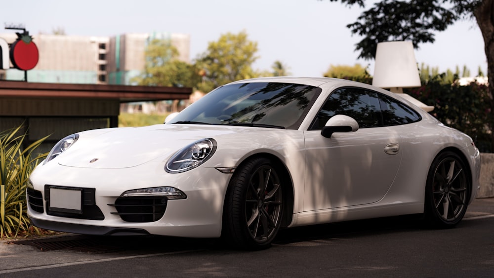 a white sports car parked on the side of the road