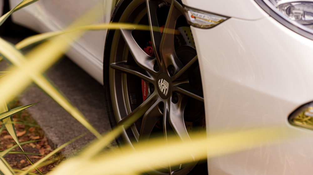 a close up of a white car parked on the side of the road