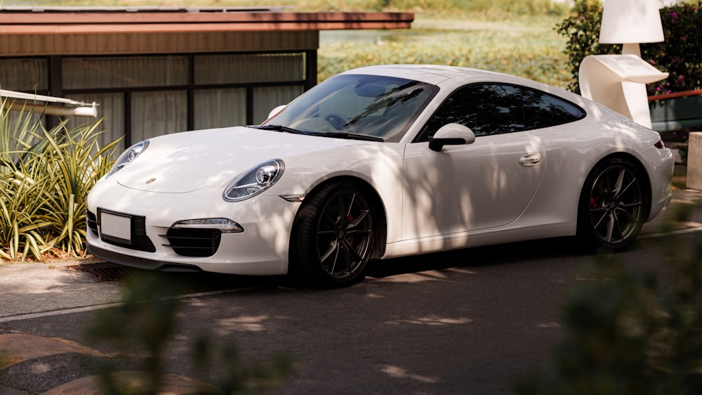 a white sports car parked in front of a house