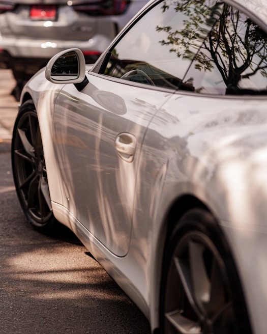 A shiny, freshly polished sports car reflecting the Stockholm skyline in its mirror-like finish