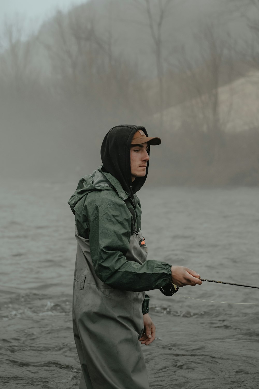 a man standing in the water holding a fishing rod