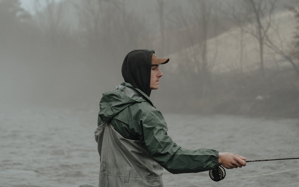 a man standing in the water holding a fishing rod