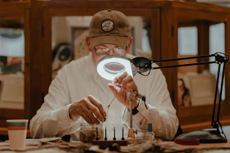 a man sitting at a table in front of a magnifying glass