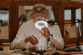 a man sitting at a table in front of a magnifying glass