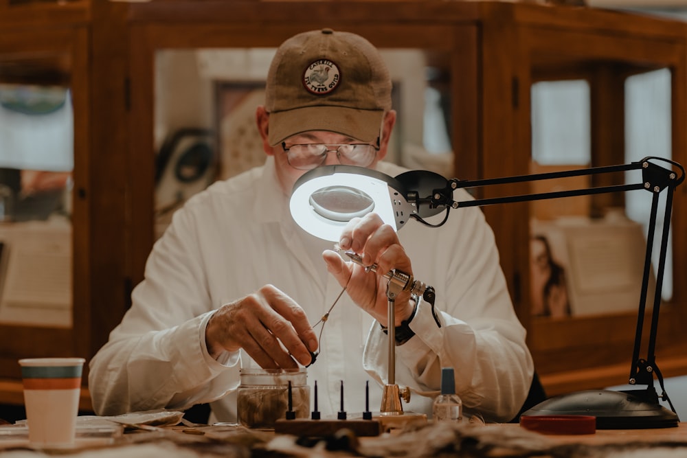 a man sitting at a table in front of a magnifying glass