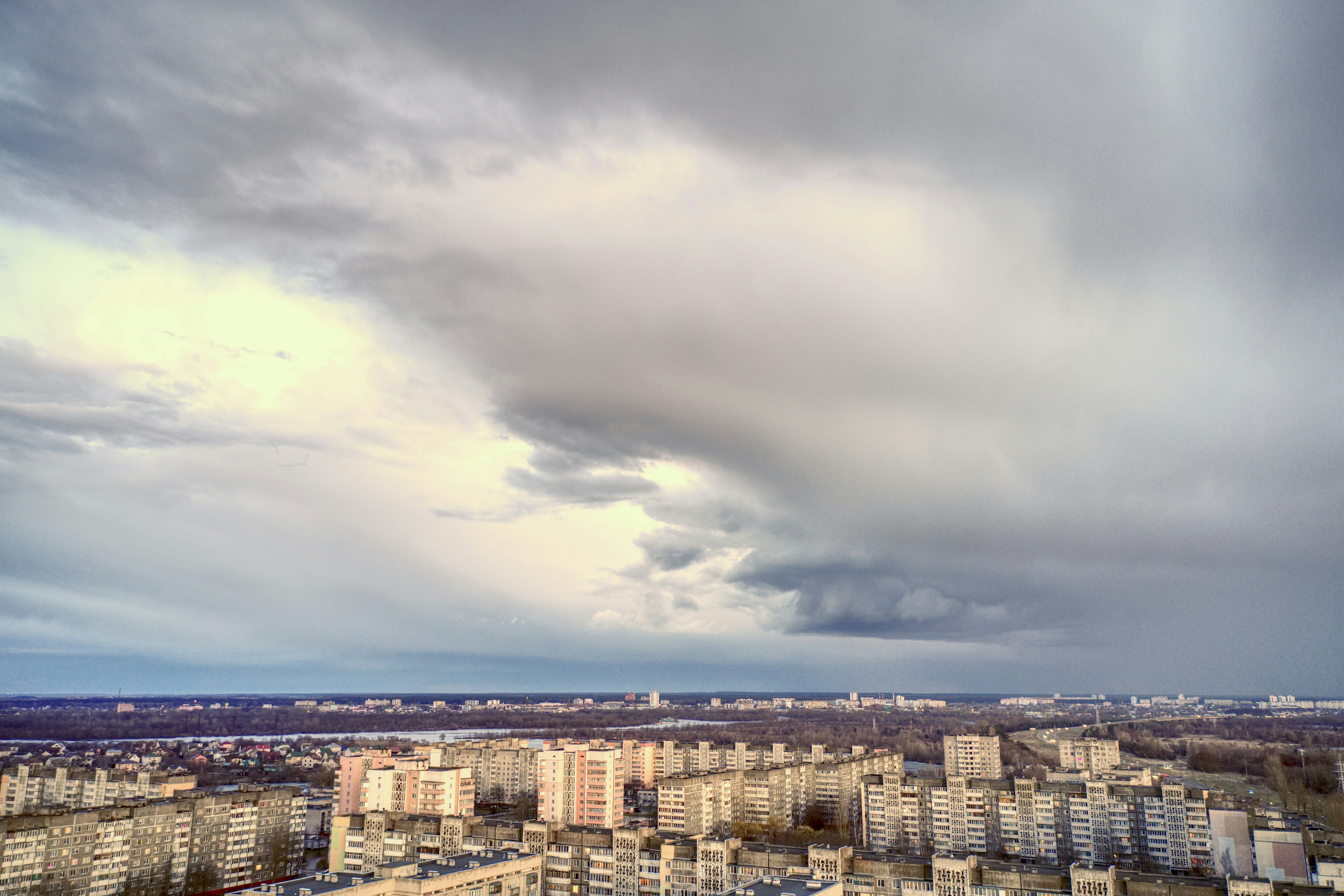 a cloudy sky over a city with tall buildings