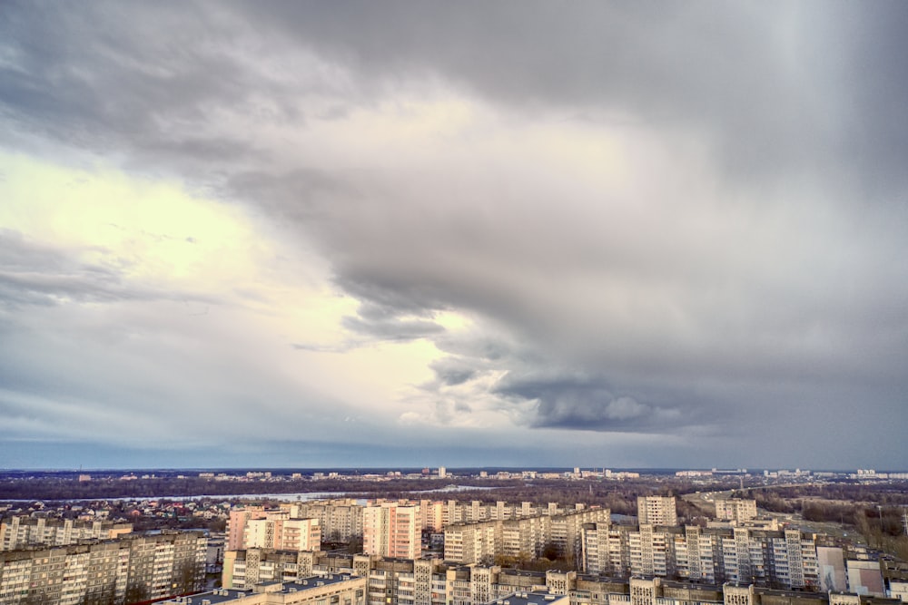 a cloudy sky over a city with tall buildings