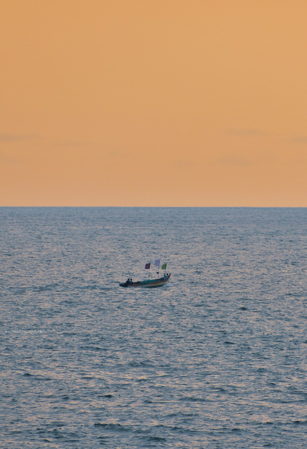 a small boat floating on top of a large body of water