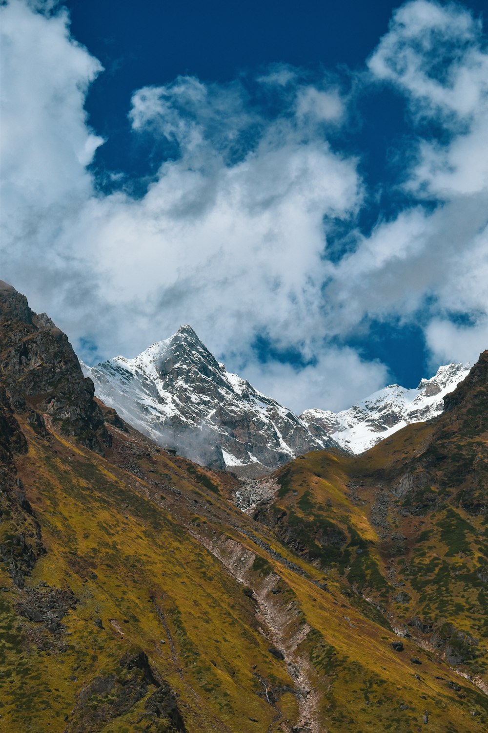 a view of a snow covered mountain with a trail going through it