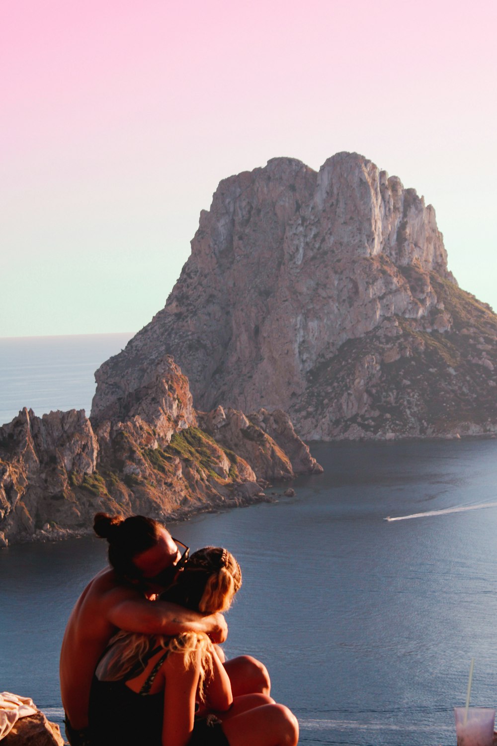 a couple of people that are sitting on a rock