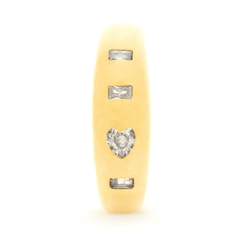 A gold ring with four embedded diamonds. The diamonds are arranged with one heart-shaped stone surrounded by three rectangular stones, aligning vertically. The gold band has a smooth, matte finish.