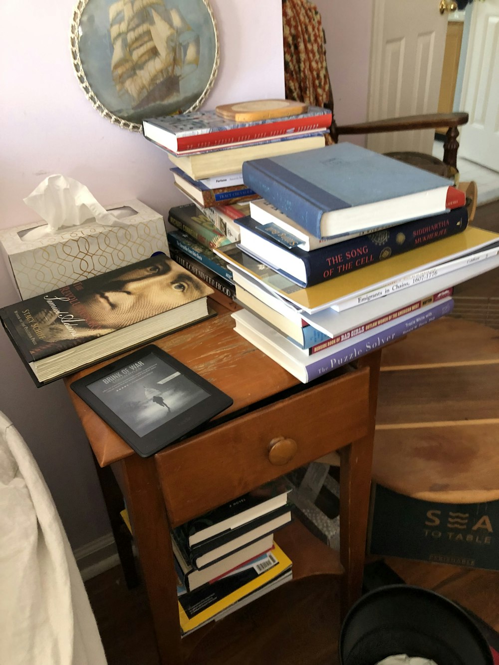 Una pila de libros sentados encima de una mesa de madera