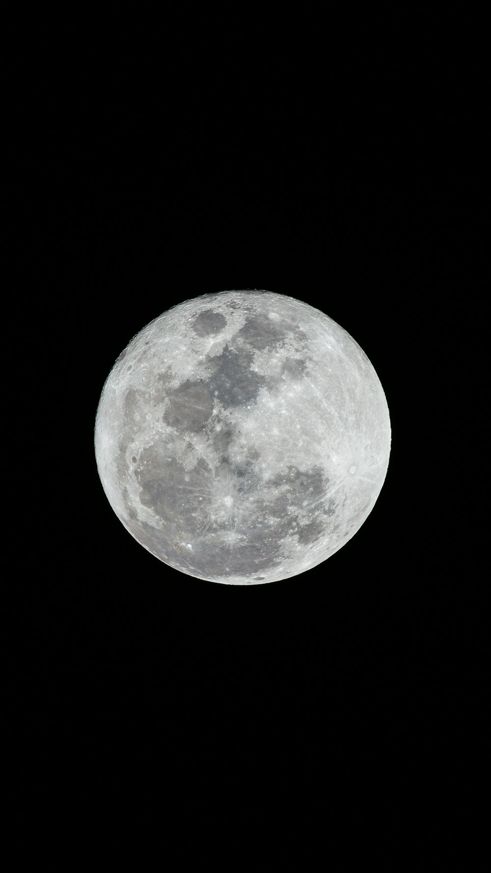 a full moon is seen in the dark sky