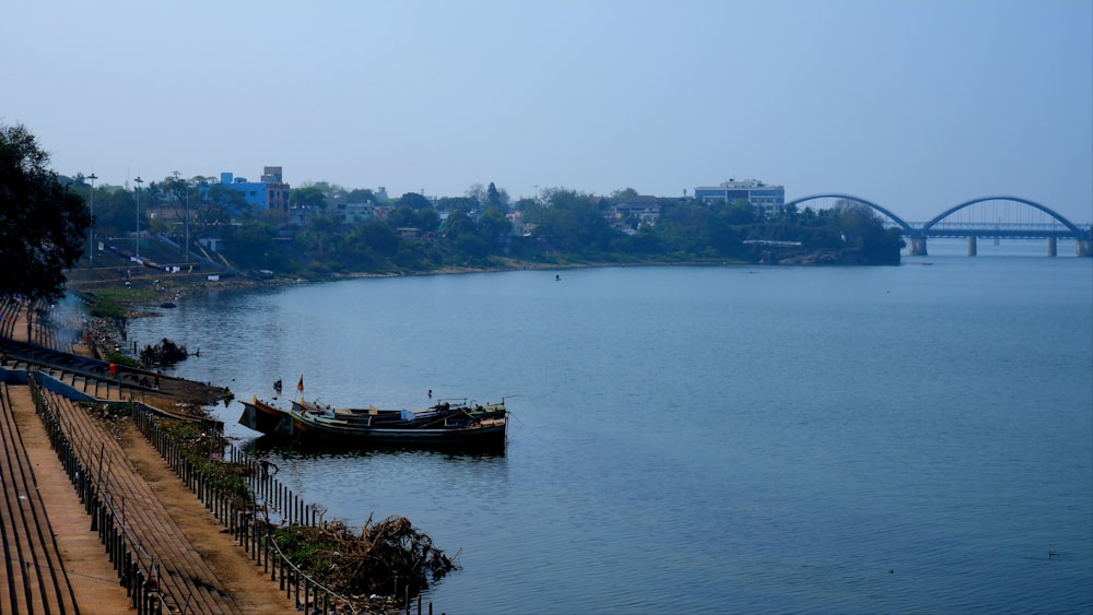 a boat on the water with a bridge in the background