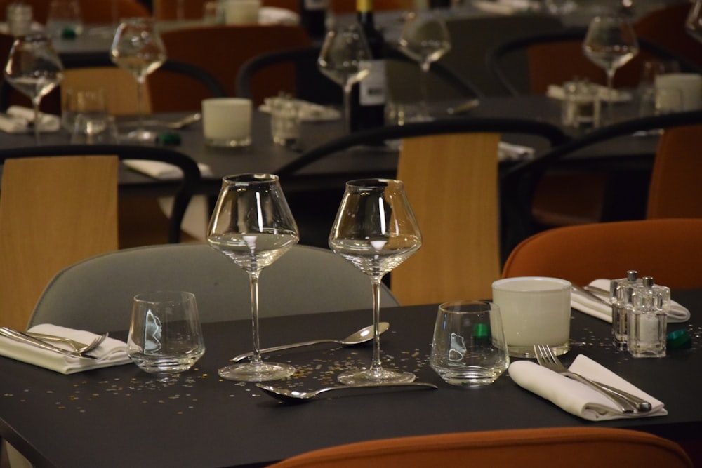 a table set up with wine glasses and silverware