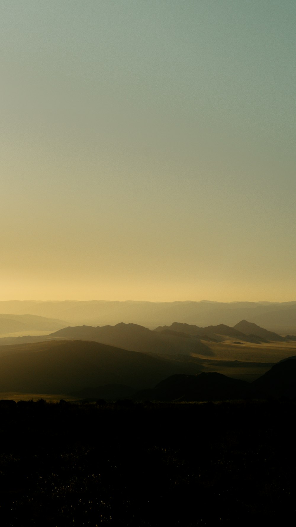 a person standing on top of a hill with a sky background