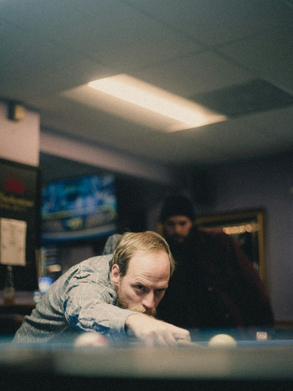 a man leaning over a pool table in a room