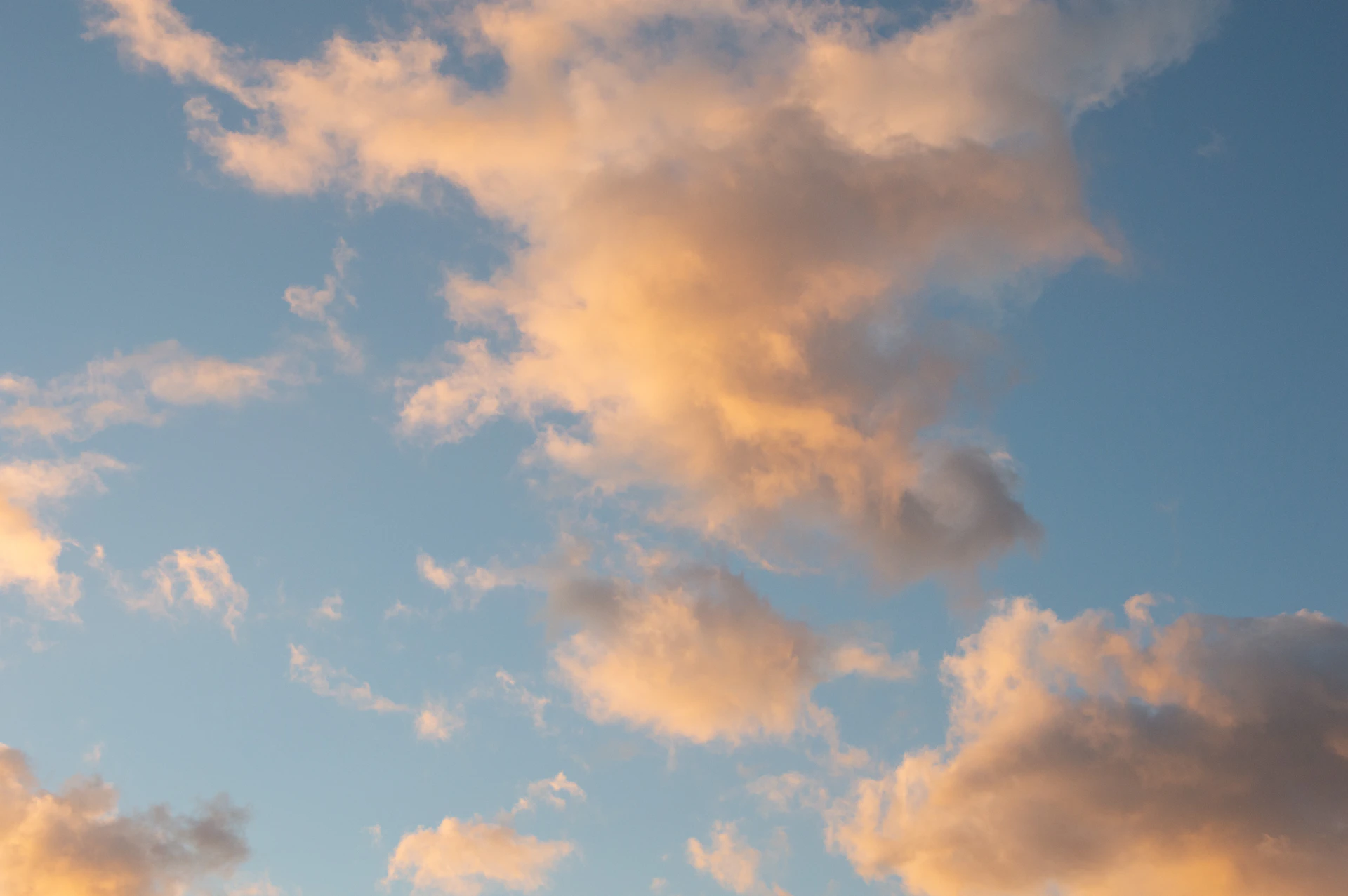 a plane flying through a cloudy blue sky