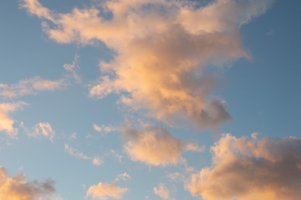 a plane flying through a cloudy blue sky