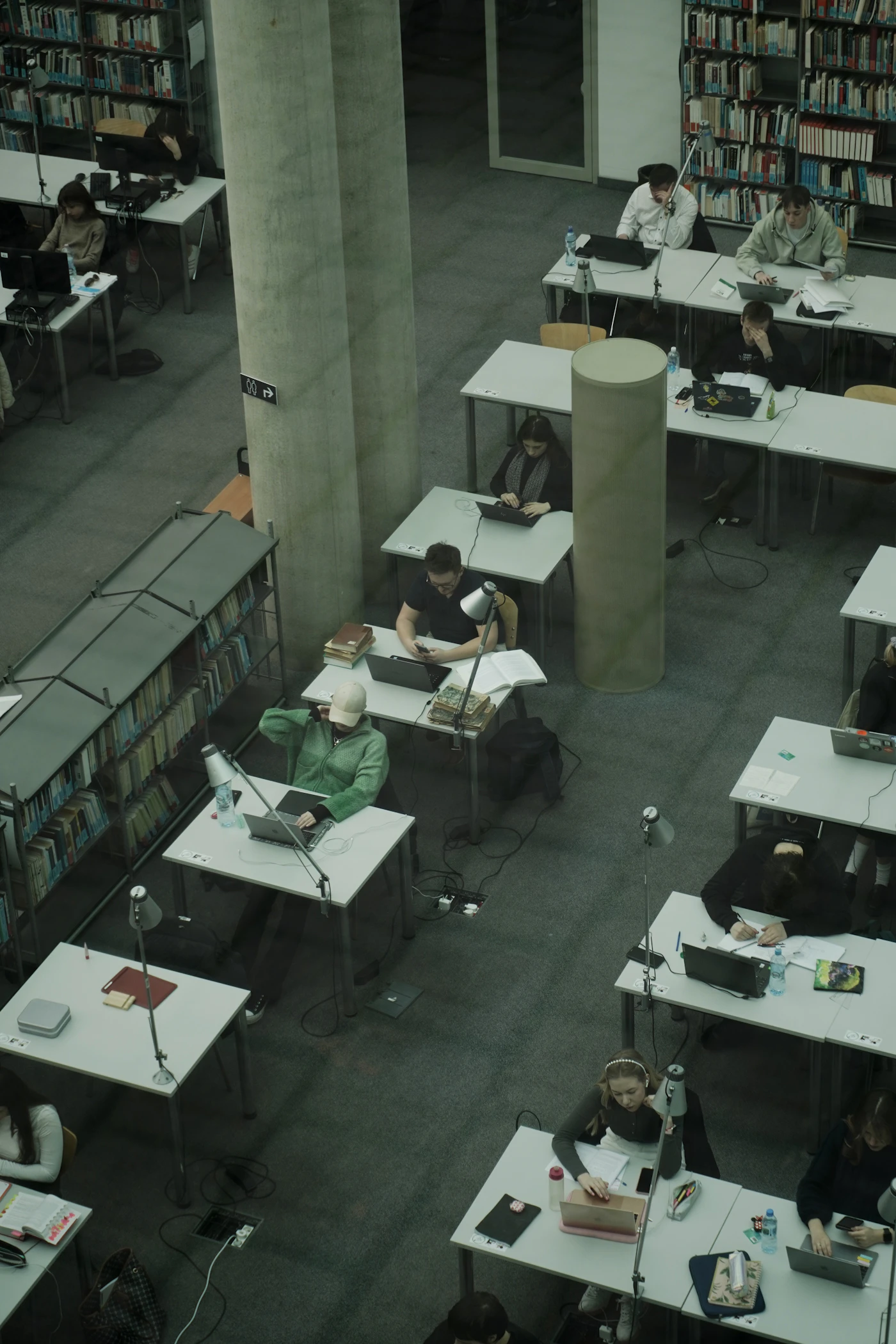 A group of college students studying together at desks in a library