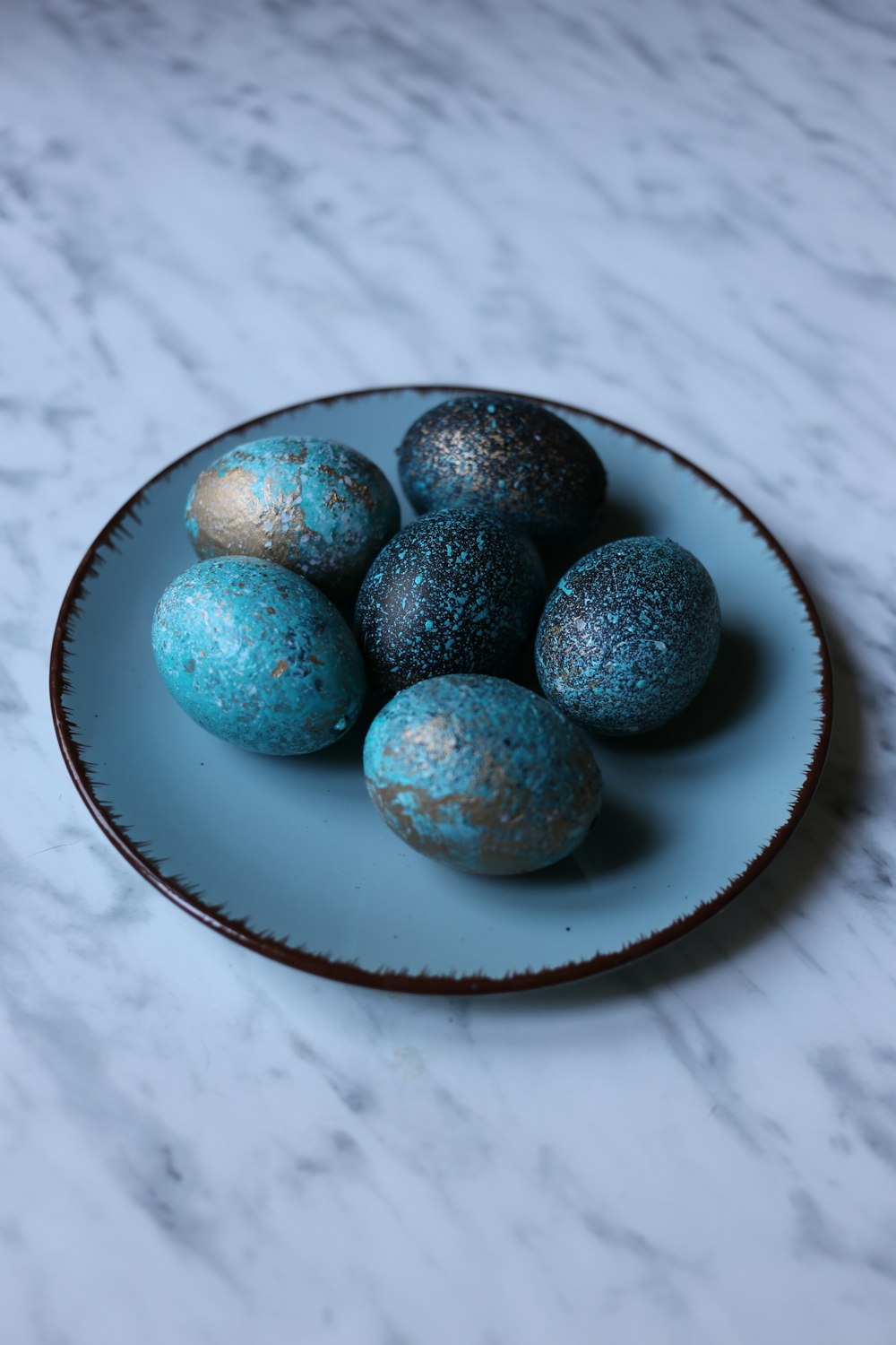 a white plate topped with blue and gold decorated eggs