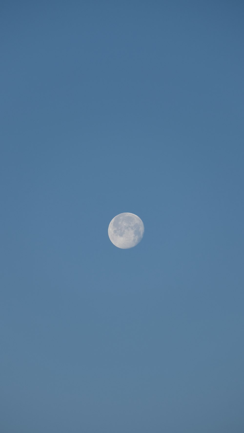 Una luna piena in un cielo azzurro e limpido
