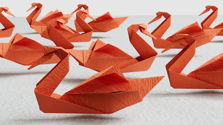 Red paper swans floating above a texture.
