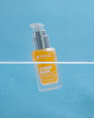 a close up of a bottle of liquid floating in the air