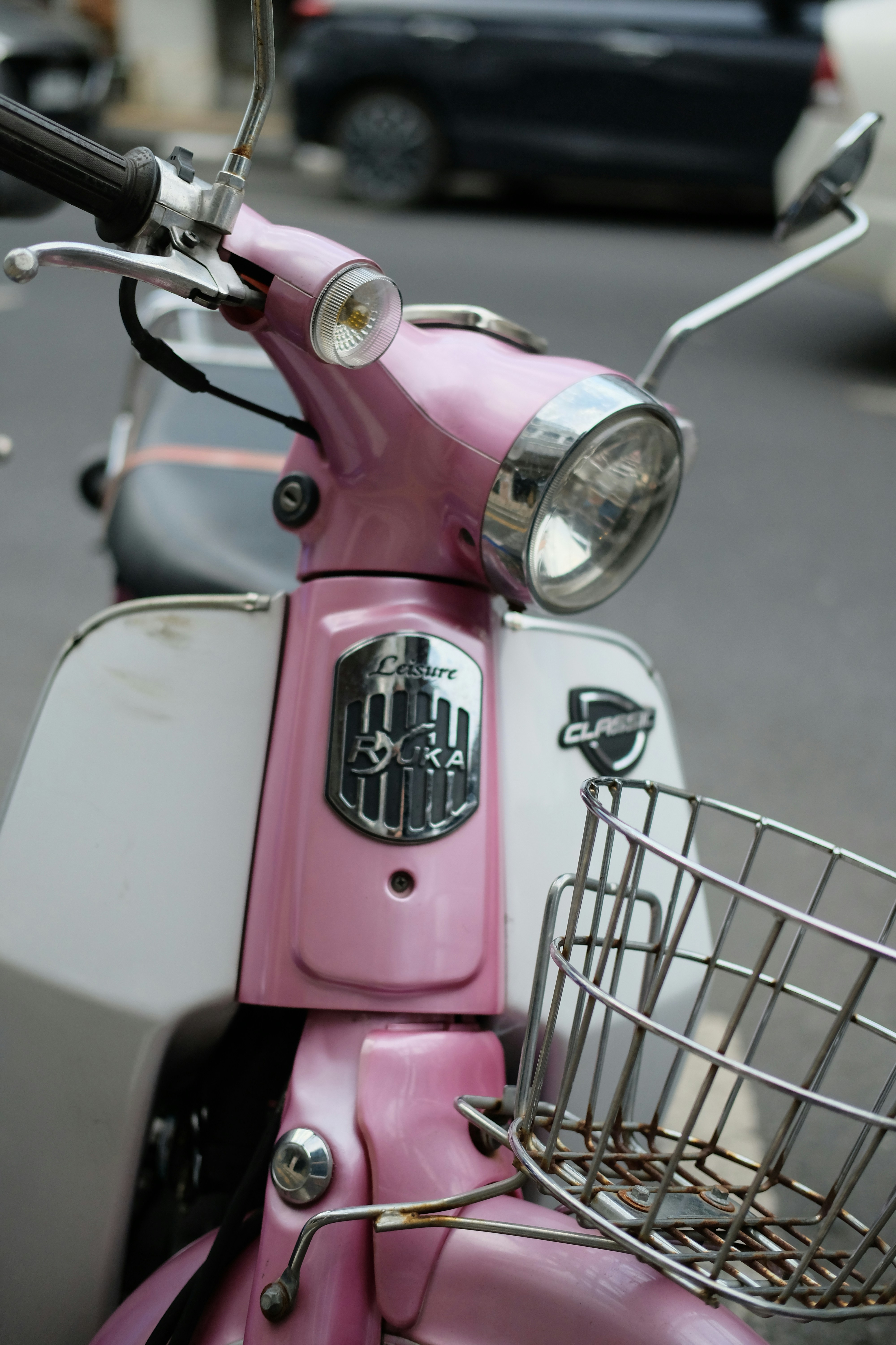 a pink scooter parked on the side of the road