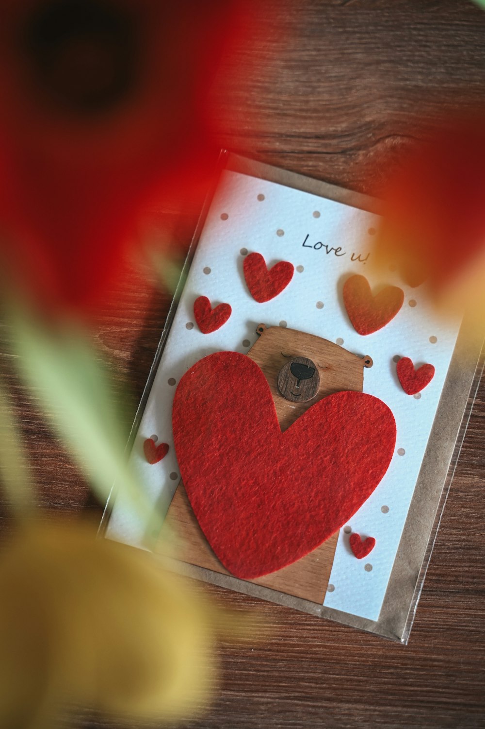 Una tarjeta con un oso y corazones en ella