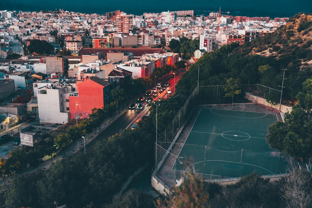 a view of a city with a soccer field in the foreground