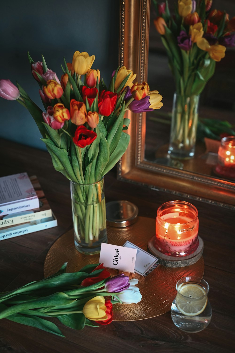 a vase filled with lots of flowers next to a candle