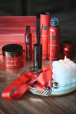 a table topped with a candle and bottles of skin care