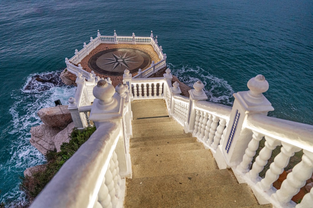 a staircase leading down to the ocean with a compass on it