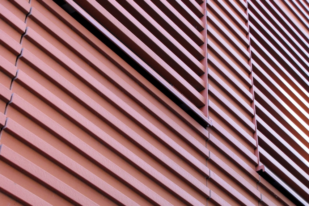 a close up view of a pink building with vertical blinds